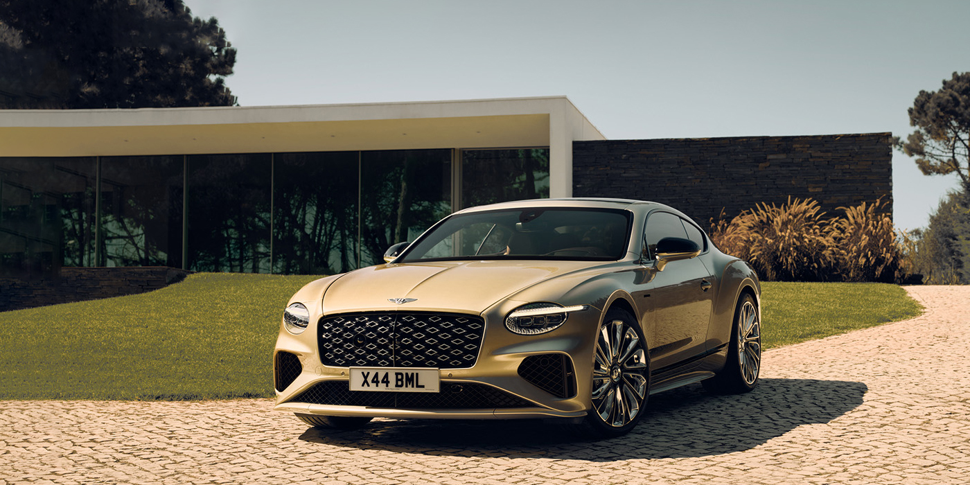 Bentley Kuala Lumpur Bentley Continental GT Mulliner coupe front three quarters in Patina paint parked outside a glass fronted building with a grass lawn behind it