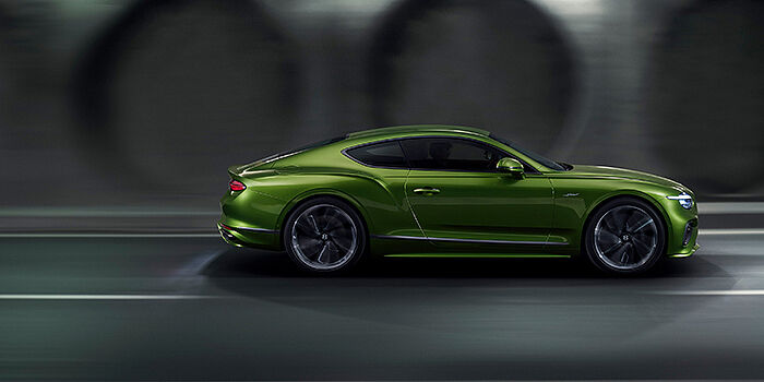 Bentley Kuala Lumpur Bentley Continental GT coupe in Tourmaline Green paint driving in profile on a dark road