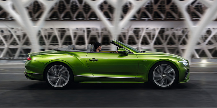 Bentley Kuala Lumpur Bentley Continental GTC Speed convertible side profile in Tourmaline Green paint driving dynamically on a bridge at night