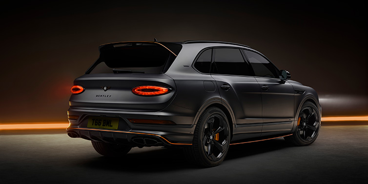 Bentley Kuala Lumpur Bentley Bentayga S Black Edition SUV rear three quarter in Anthracite Satin paint against a dark red and yellow background