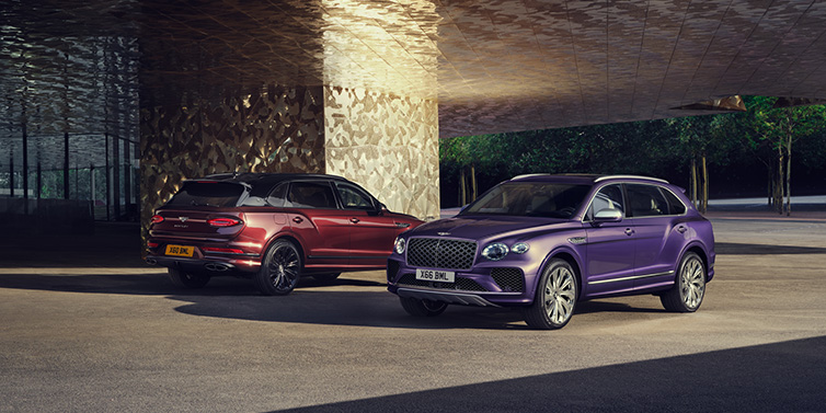 Bentley Kuala Lumpur A duo of Bentley Bentayga Extended Wheelbase Mulliner SUVs parked in a city environment, with Tanzanite Purple and Cricket Ball red exterior paint