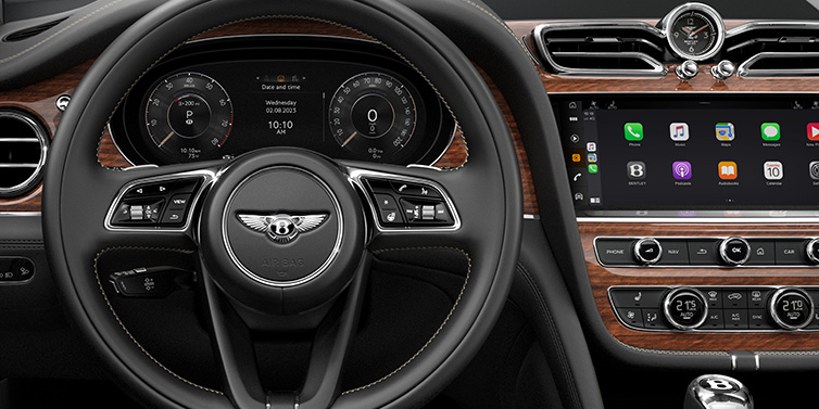 Bentley Kuala Lumpur Bentley Bentayga SUV front interior detail of steering wheel and driver screens surrounded by Beluga black hide and Crown Cut Walnut veneer