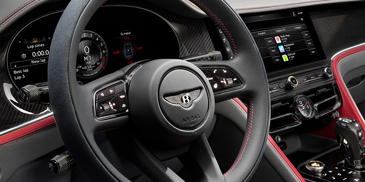 Bentley Kuala Lumpur Bentley Flying Spur Speed sedan front interior detail showing steering wheel and driver screens surrounded with Hotspur red and Gravity Grey hides